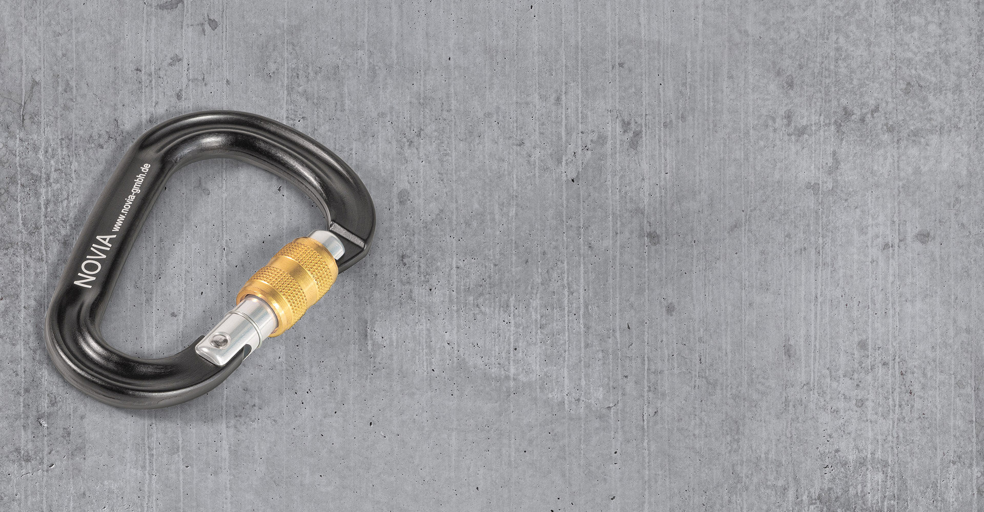 NOVIA-Artwork: Grauer NOVIA-Karabiner mit weißem Logo und goldener Sicherung