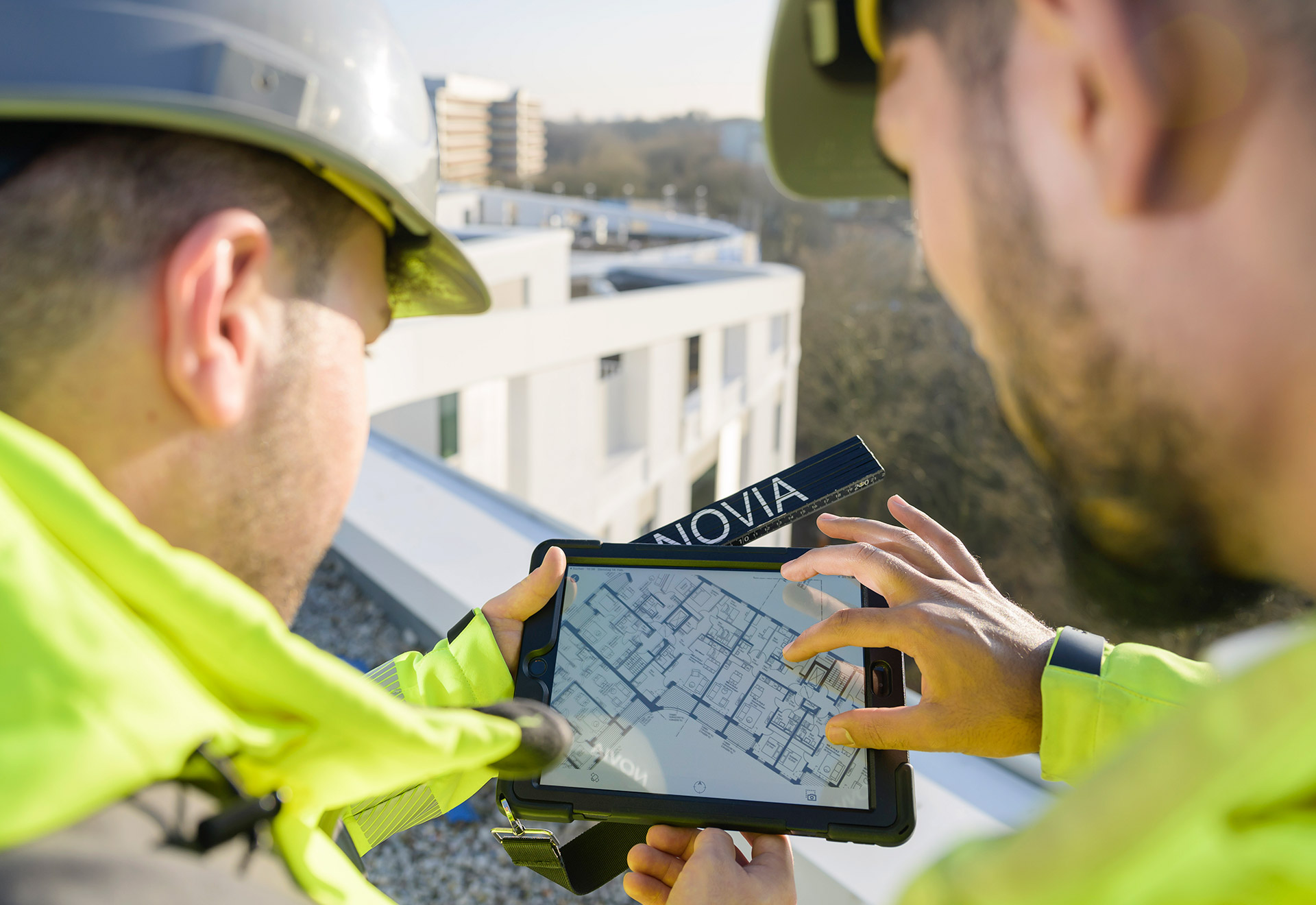 NOVIA GmbH Consulting und Baumanagement - Projektleiter gleichen bei Vororttermin den digitalen Bauplan mit der Baustelle ab